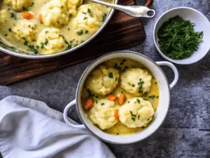 Ingredients for Bisquick dumplings on a wooden board, including Bisquick mix and milk.
