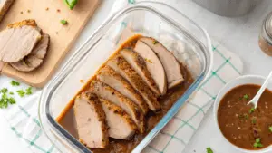 Medium-rare 3 lb roast sliced on a cutting board with herbs and a sous vide machine